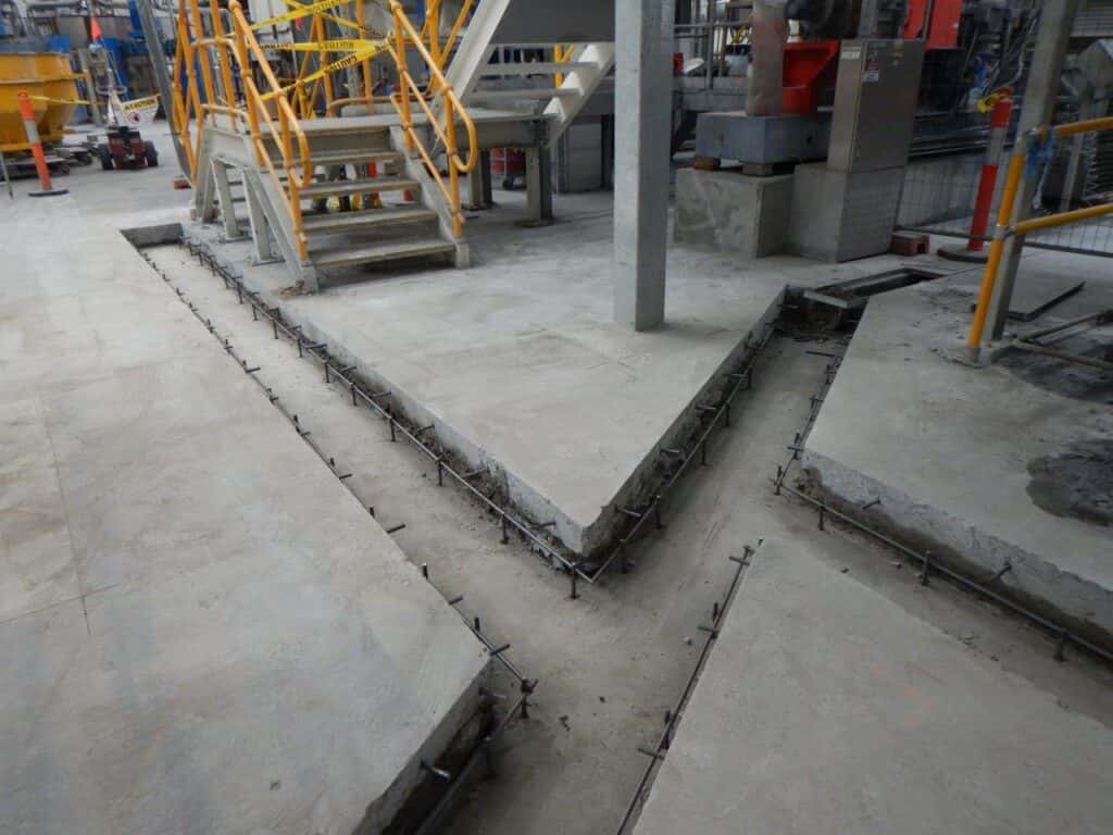 Concrete floor edges beside factory equipment