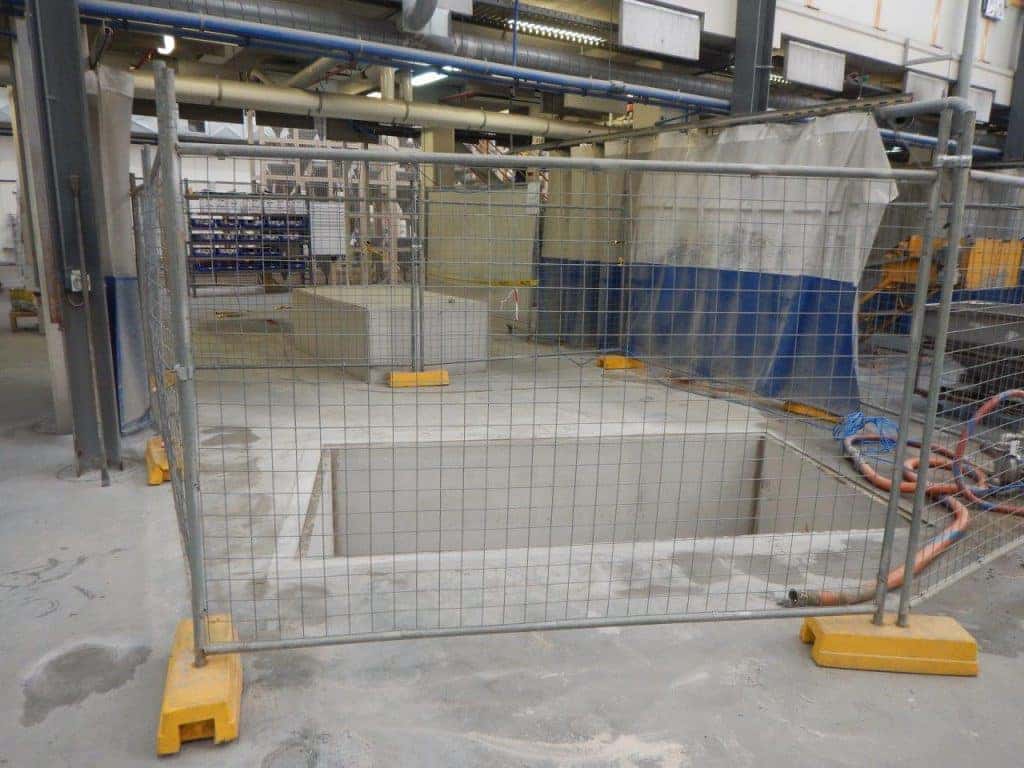 Industrial concrete works behind temporary fencing