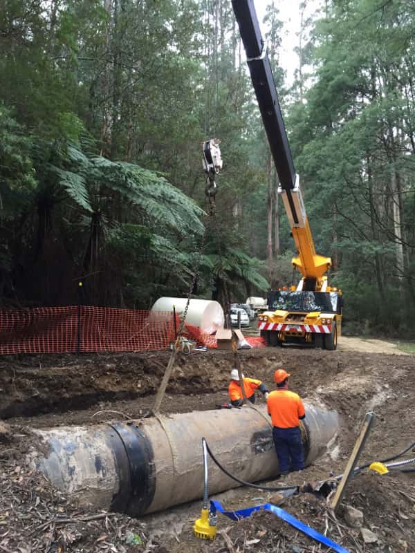 Workers and lifting equipment on a pipeline site