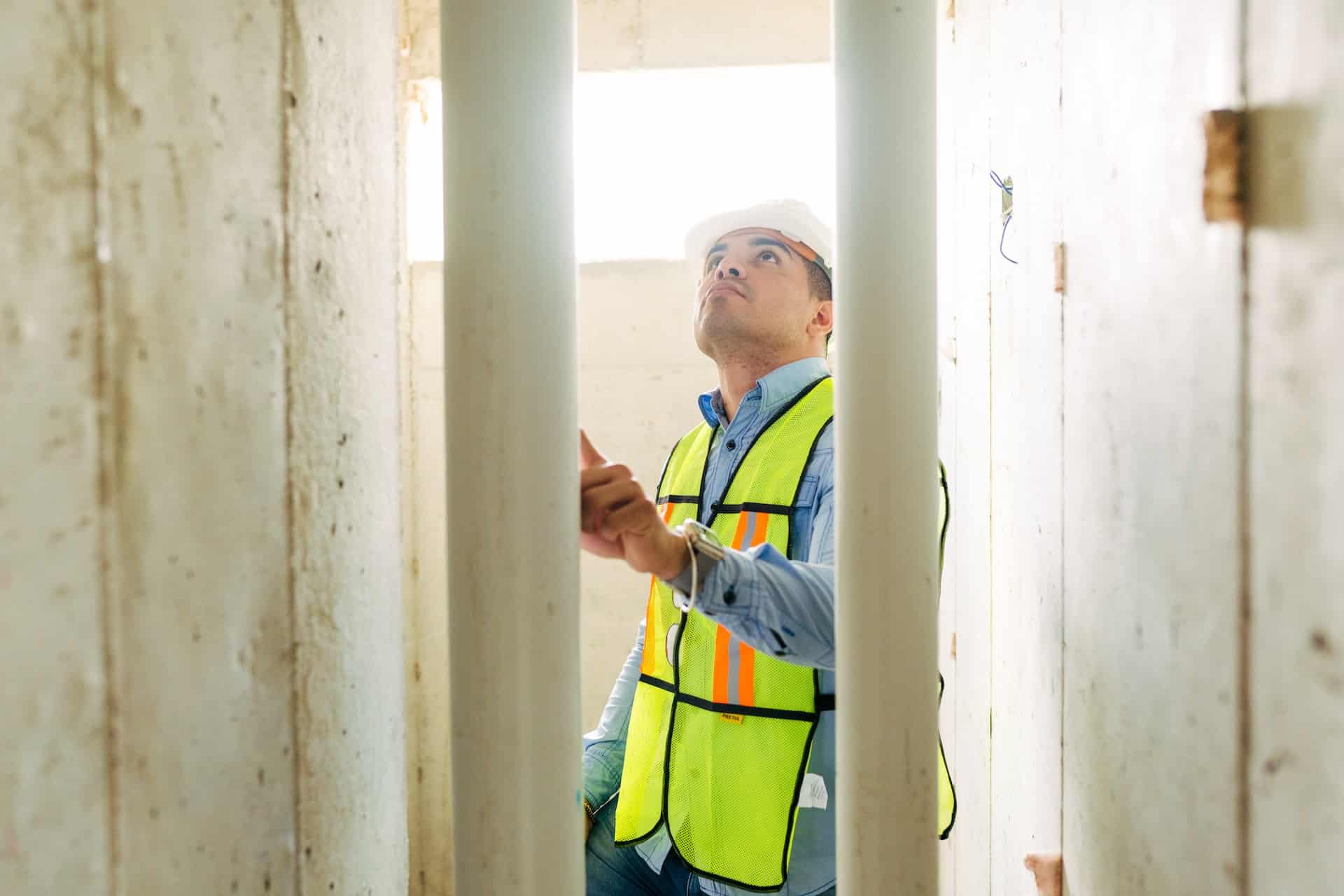 Worker inspecting building pipes