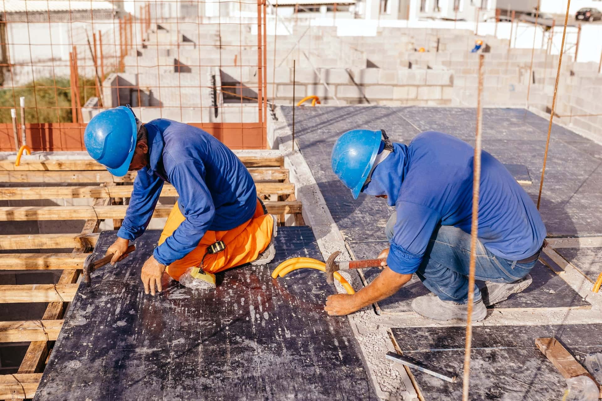 Construction workers pour concrete.