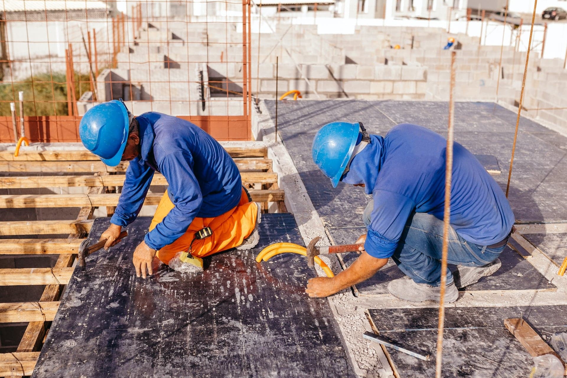 Construction workers pour concrete.